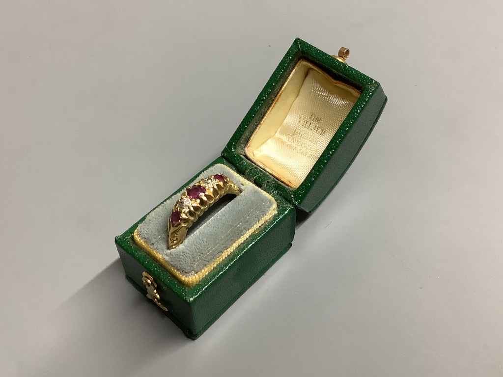 An Edwardian 18ct gold, three stone ruby and two stone diamond set half hoop ring
